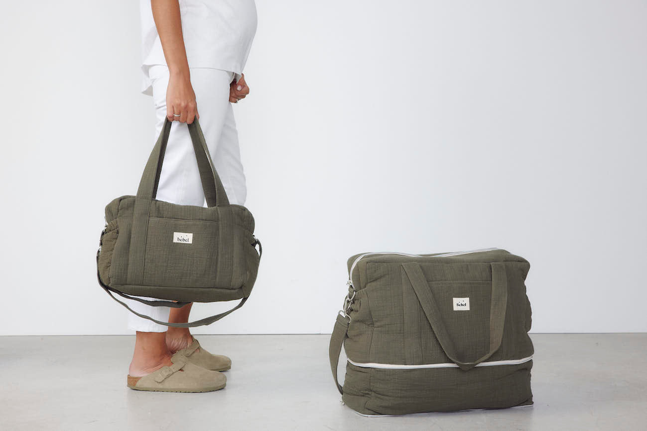 image d'une femme enceinte tenant un sac middle kaki de chez bebel et d'un sac 24/48h kaki au sol Image